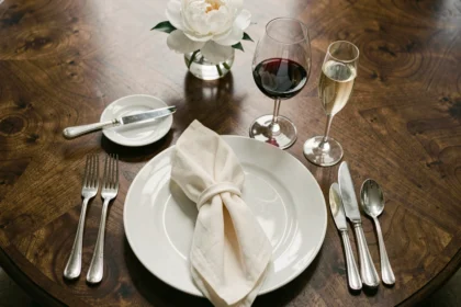 Table française dressée avec trois verres disposés selon l'étiquette traditionnelle, vue plongeante sur vaisselle et cristal